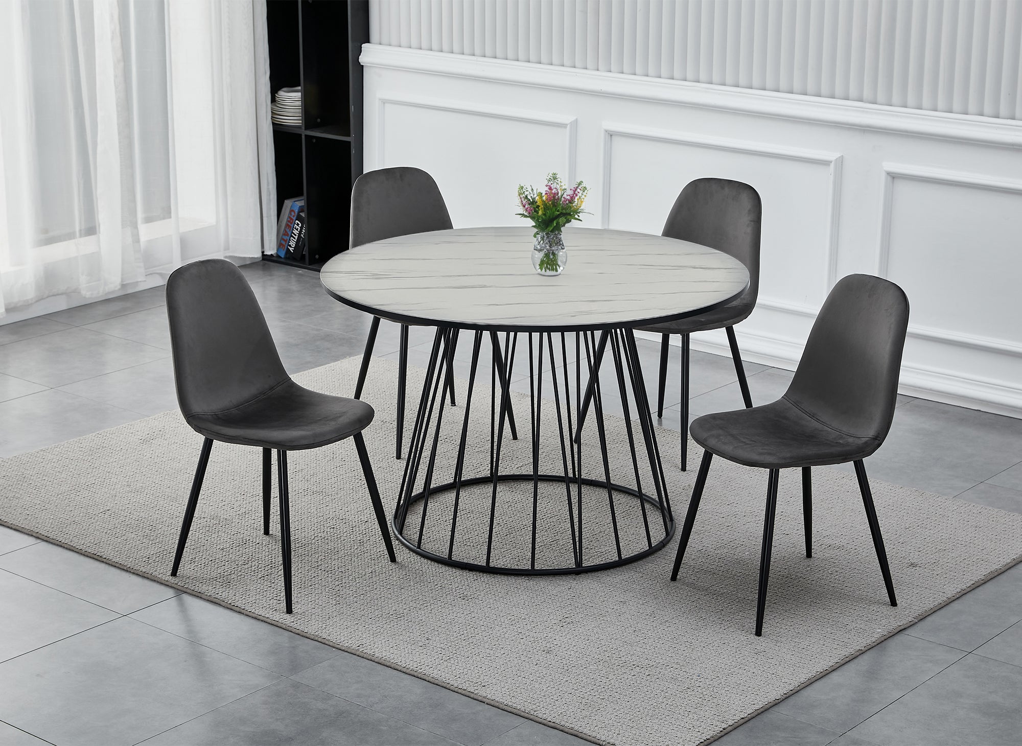 Mesa de comedor redonda Stella con efecto mármol blanco y base de metal negro.