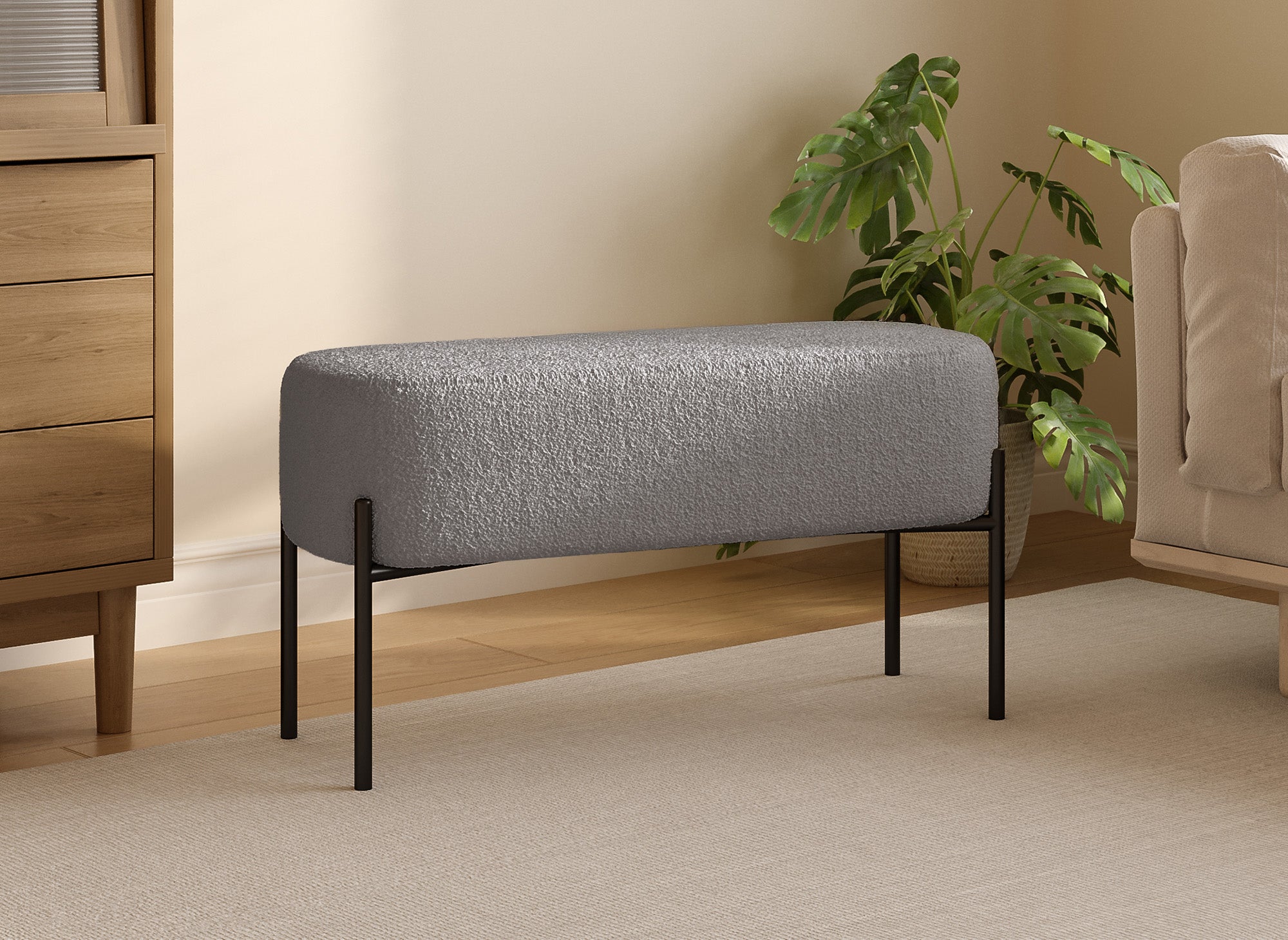 Banco LEYAN tapizado en tela gris con efecto piel de oveja y patas de metal negro.