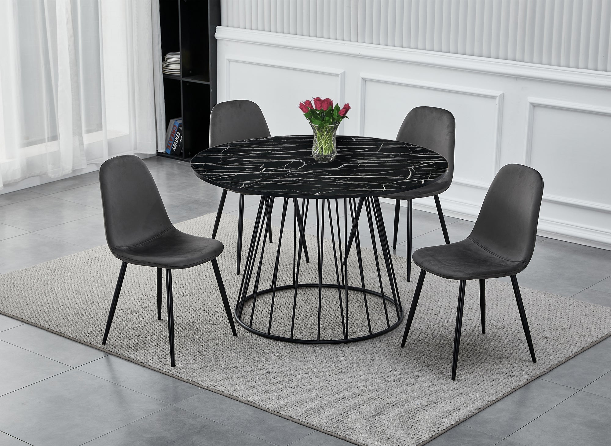 Mesa de comedor redonda Stella con efecto mármol negro y base de metal negro.