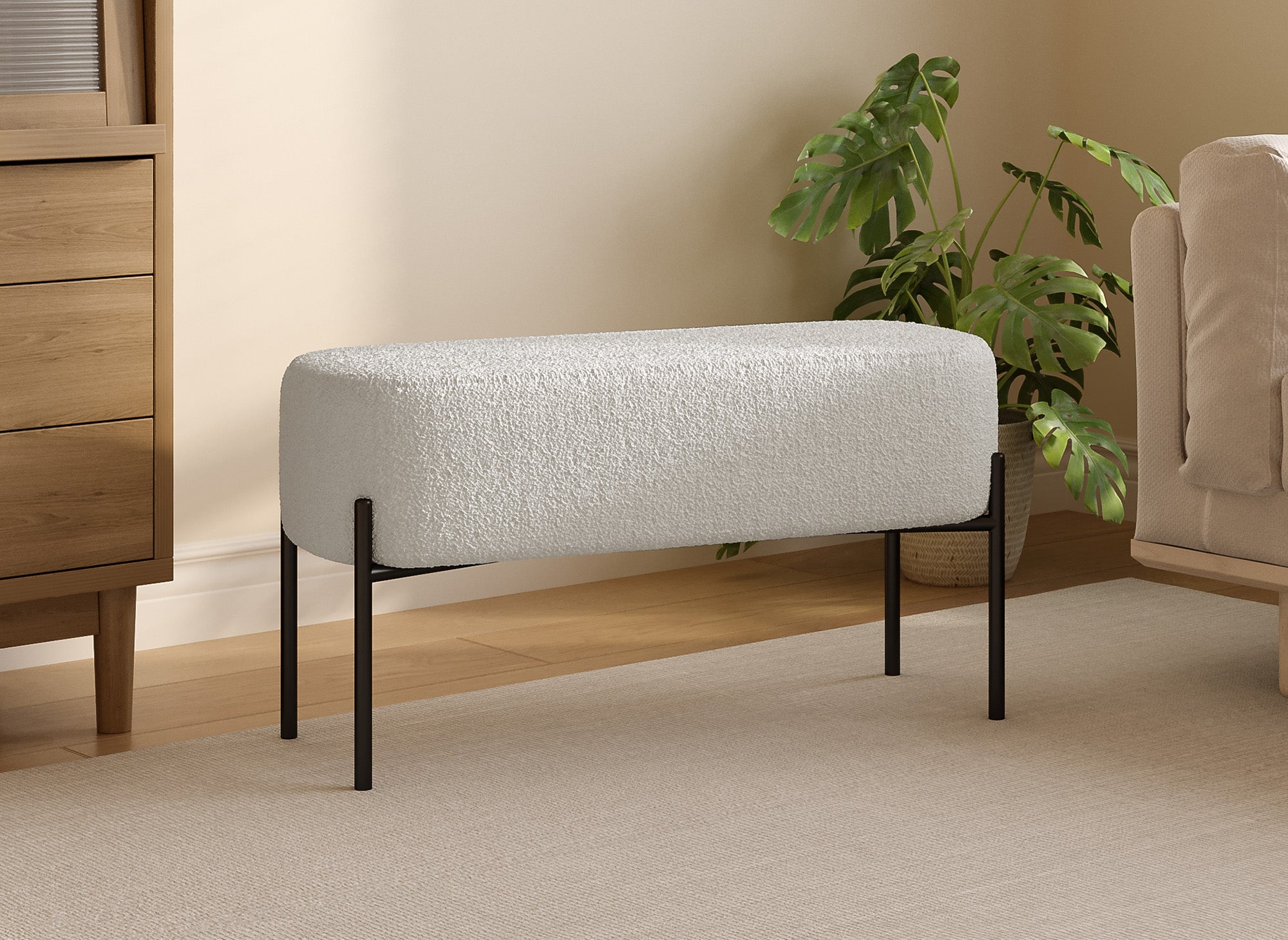 Banco LEYAN tapizado en tela color crudo con efecto piel de oveja y patas de metal negro.